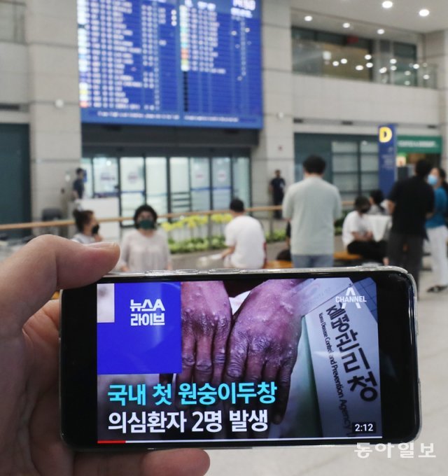 22일 인천국제공항에서 한 시민이 스마트폰으로 원숭이두창 관련 뉴스를 시청하고 있다. 인천=홍진환 기자 jean@donga.com