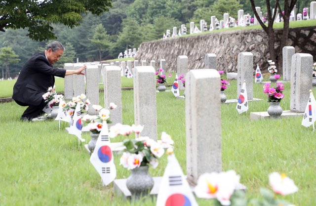 6.25 전쟁 발발 72주년을 하루 앞둔 24일 서울 동작구 국립서울현충원 6.25 전사자 묘역에서 유가족이 아버지 묘비를 만져보고있다.