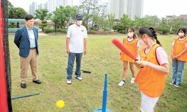 한국야구위원회(KBO)는 24일 경기 안산원곡초등학교에서 올해 첫 ‘찾아가는 티볼 교실’을 열었다. 한 여학생이 티볼을 치는 모습을 허구연 KBO 총재(왼쪽)가 지켜보고 있다. KBO 제공