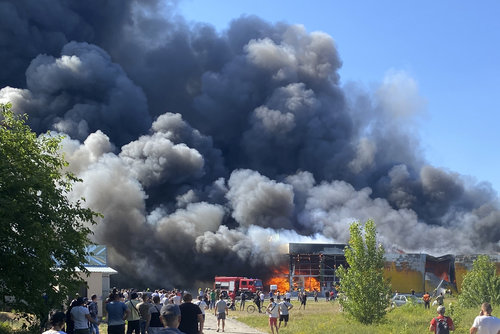 27일 우크라이나 크레멘추크에서 시민들이 러시아의 미사일 공격으로 연기가 솟구치는 쇼핑몰을 지켜보고 있다. 크레멘추크=AP 뉴시스