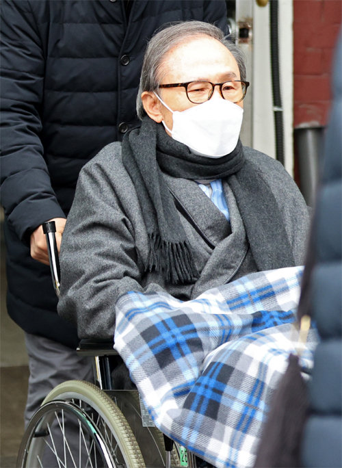 지난해 2월 휠체어에 탄 이명박 전 대통령이 서울 종로구 서울대병원에서 치료를 받은 뒤 퇴원하고 있다. 뉴시스