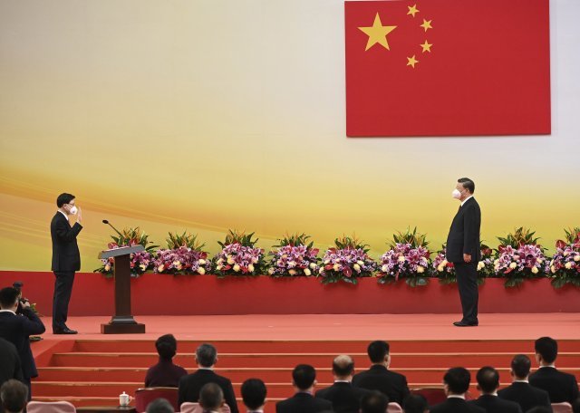 시진핑(오른쪽) 중국 국가주석이 홍콩 반환 25주년인 1일 홍콩에서 존 리 신임 행정장관의 취임식에 참석해 선서를 받고 있다  홍콩=AP/뉴시스
