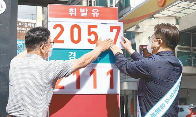 박일준 산업통상자원부 2차관(오른쪽)이 1일 서울 강서구의 알뜰목화주유소에서 유류세 인하분을 반영해 가격표를 바꾸고 있다. 뉴시스