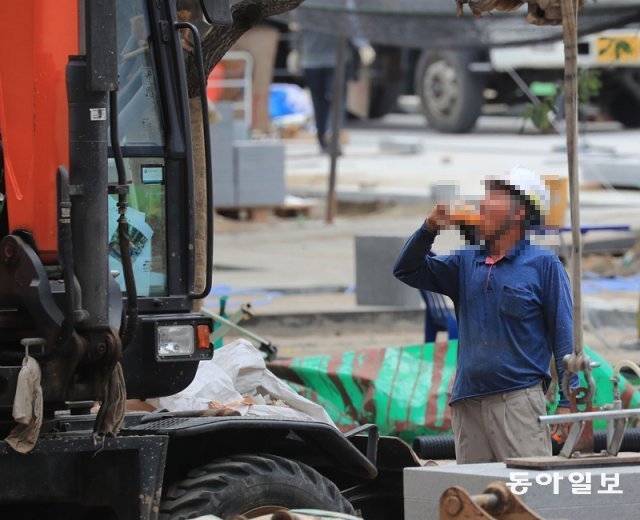 4일 오후 종로구 광화문광장 공사현장에서 더위에 지친 근로자가 음료수를 마시고 있다. 김재명 기자 base@donga.com