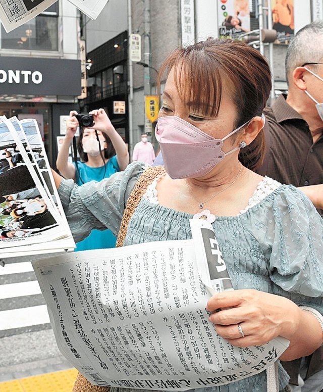 ‘아베 피격’ 日신문 호외 발행 8일 일본 도쿄 신바시에서 시민들이 아베 신조 전 총리의 피격 소식을 전하는 아사히신문의 호외를 가져가고 있다. 아사히신문 제공