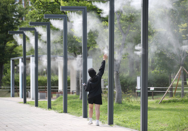 본격적인 더위가 시작되는 소서인 7일 부산 부산진구 부산시민공원 쿨링포그 아래에서 한 시민이 더위를 피하고 있다. 20222.7.7/뉴스1