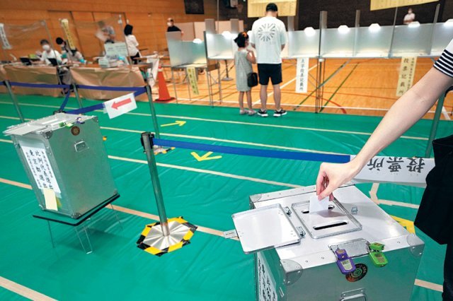 일본 참의원(상원) 선거날인 10일 도쿄의 한 투표소에서 유권자가 투표용지를 투표함에 넣고 있다. 도쿄=AP 뉴시스