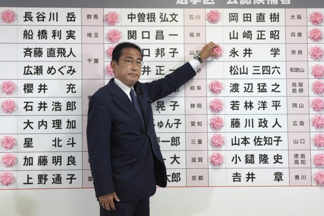 기시다 후미오 일본 총리 겸 자민당 총재가 지난 10일 도쿄 자민당사에서 후보자 이름에 붉은 장미를 달아 참의원 선거 승리를 알리고 있다. 도쿄= AP뉴시스