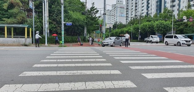 보행자 보호 의무를 강화한 도로교통법 개정안 시행일인 12일 충북 청주시 상당구 용암농협 사거리에서 한 경찰관이 우회전 차량을 대상으로 통행 유도를 하고 있다.2022.7.12/© 뉴스1