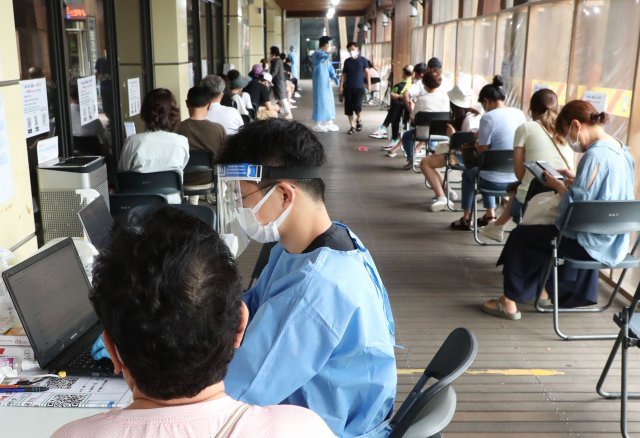 전날 코로나19 확진자 수가 3만 명을 넘은 12일 오전 서울 송파구 보건소를 찾은 주민들이 PCR검체를 채취하기 위해 기다리고 있다. 신원건 기자 laputa@donga.com