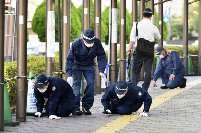 일본 경찰이 13일 일본 서부 나라현에서 아베 신조 전 일본 총리가 총격으로 쓰러진 현장 인근 보도를 조사하고 있다. AP/뉴시스