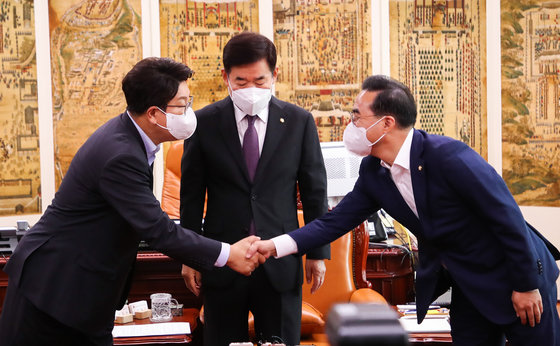 권성동 국민의힘 대표 직무대행 겸 원내대표(왼쪽)와 박홍근 더불어민주당 원내대표가 지난 12일 오전 국회에서 열린 회동에서 악수하고 있다. 가운데는 김진표 국회의장. 2022.7.12 사진공동취재단