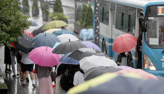 호우주의보가 발효된 18일 부산 금정구 부산대역 버스정류장에 우산 쓴 시민들이 버스를 타려고 줄 서고 있다. 2022.7.18/뉴스1