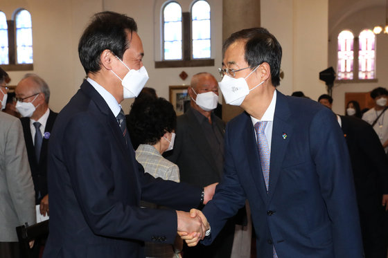 한덕수 국무총리와 우상호 더불어민주당 의원(왼쪽)이 10일 오전 서울 중구 대한성공회 서울주교성당에서 열린 제35주년 6.10 민주항쟁 기념식에서 인사나누고 있다. 2022.6.10/뉴스1 © News1