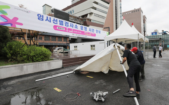 운영 재개를 하루 앞둔 21일 서울 서초구 고속버스터미널 임시선별검사소에서 관계자들이 그늘막 설치 및 운영준비를 하고 있다. 2022.7.21/뉴스1 © News1