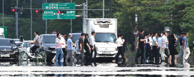 삼복더위의 두 번째 ‘중복’인 26일 오후 서울 여의도공원 앞 횡단보도에 아지랑이가 피어오르고 있다. 동해안을 제외한 전국 대부분으로 ‘폭염특보’가 내려진 가운데 서울 낮 기온 33도, 대구는 34도까지 치솟으며 무더위가 계속될 전망이다. 2022.7.26/뉴스1