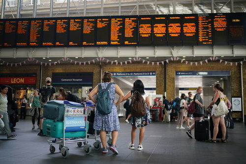 20일 승객들이 영국 런던 킹스크로스역에서 열차 일정을 확인하고 있다. 최근 영국에서는 파업과 기록적인 폭염에 따른 설비 문제로 열차 운행에 차질이 발생하고 있다. 런던=AP·뉴시스