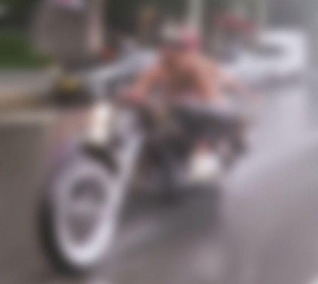 상의를 탈의한 남성이 비키니를 입은 여성을 오토바이 뒤에 태우고 서울 시내를 달리고 있는 모습. 뉴스1