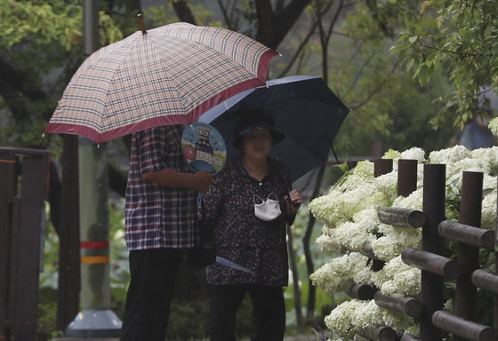 울산 남구 선암호수공원에서 우산을 쓴 시민들이 부채질을 하고 있다. 2022.7.28/뉴스1 ⓒ News1