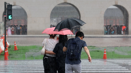 소나기가 내린 6일 서울 종로구 광화문 앞 삼거리도로에서 우산을 쓴 시민들이 발걸음을 옮기고 있다. 2022.8.6/뉴스1