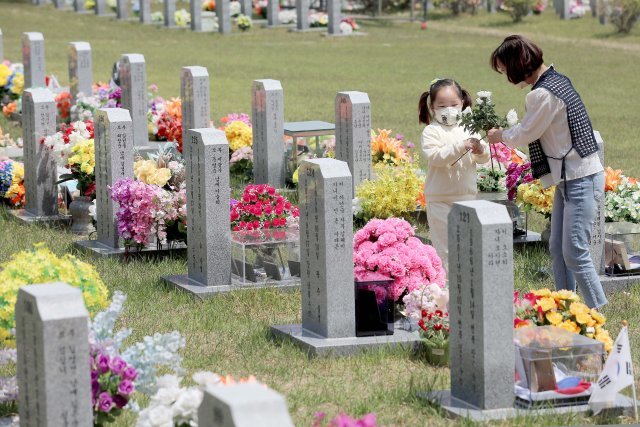 5월 12일 현충원 묘역에서 순직 소방관들의 묘비 앞에 하얀 국화를 놓고 있는 박현숙(오른쪽)과 딸 소윤.