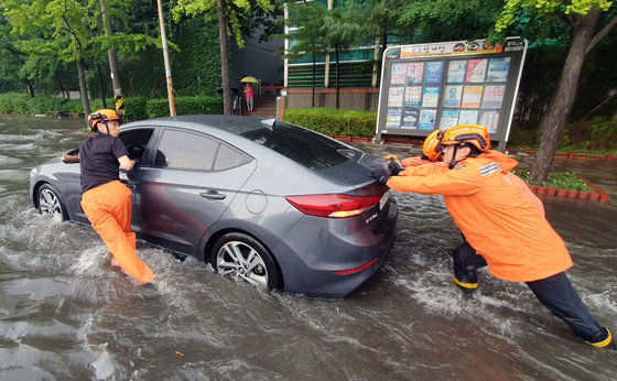 폭우가 내린 8일 인천시 미추홀구 용현동의 한 거리에 차량이 침수돼 소방대원들이 안전조치를 하고 있다. (인천소방본부 제공) 2022.8.8/뉴스1