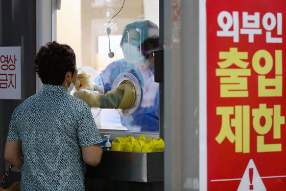 8일 오전 서울 용산구 보건소에 마련된 신종 코로나바이러스 감염증(코로나19) 선별검사소에서 한 시민이 검체 검사를 받고 있다. 2022.8.8/뉴스1