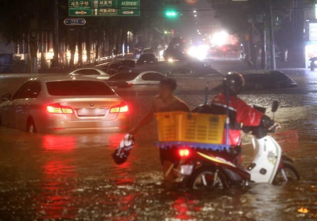 서울과 경기북부 등 수도권에 폭우가 내린 지난 8일 오후 서울 강남구 일대 도로가 침수돼 차량이 잠겨 있다. 뉴시스