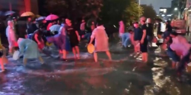 충북 청주시 흥덕구 복대동의 한 아파트 주민들이 빗물을 퍼내고 있다. 청주방송 갈무리