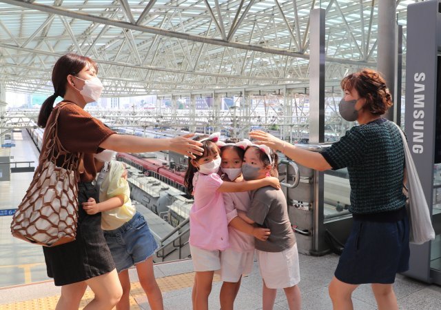올해 7월 3일 서울역. 박현숙(오른쪽)과 딸 소윤(오른쪽 두 번째)이 기차를 타러 가기 전에 다른 소방관 유가족과 손을 잡으려 하고 있다.