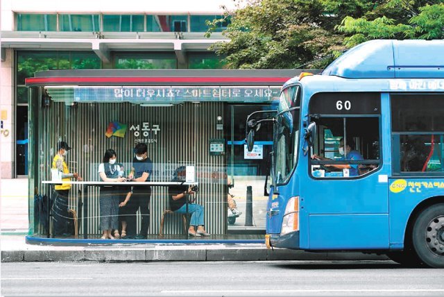 서울 성동구의 한 버스정류장 인근에 설치된 스마트쉼터에서 시민들이 버스를 기다리며 휴식을 취하고 있다. 에어컨과 공용 인터넷 등이 설치된 스마트쉼터는 현재 성동구에 47곳이 설치됐다. 성동구 제공
