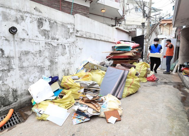 15일 지난주 집중호우로 수해피해를 입은 서울 동작구 상도동의 한 주택에서 자원봉사자가 물에 젖은 가재도구를 밖으로 옮기고 있다.