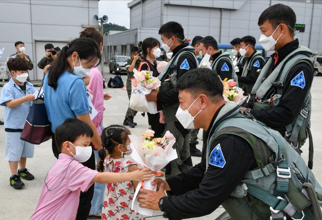 공군 특수비행팀 블랙이글스가 20일 군사외교 및 방산협력을 위한 해외에어쇼 임무를 성공적으로 마치고 무사귀환했다. 조종사들이 마중나온 가족들과 재회하고 있다. 공군 제공
