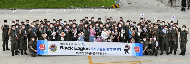 공군 특수비행팀 블랙이글스가 20일 군사외교 및 방산협력을 위한 해외에어쇼 임무를 성공적으로 마치고 무사귀환했다. 블랙이글스 임무요원들과 장병 및 가족들이 기념사진을 찍고있다. 공군 제공