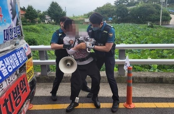 16일 오전 문재인 전 대통령 사저가 있는 양산 하북면 평산마을 앞 도로에서 흉기를 휘두른 60대 남성이 경찰에 체포되고 있다. 뉴스1/독자 제공
