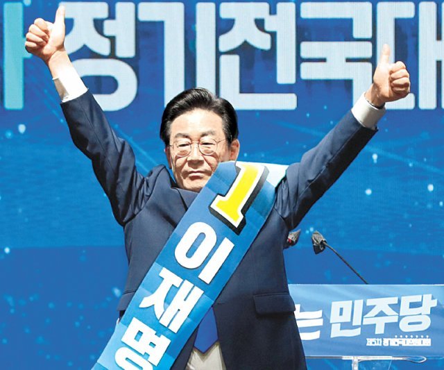 더불어민주당 이재명 신임 당 대표가 28일 서울 올림픽공원 체조경기장에서 열린 정기전국대의원대회에서 당 대표로 선출된 뒤 양손을 들고 인사하고 있다. 사진공동취재단