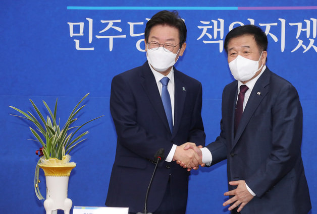 이재명 더불어민주당 대표가 30일 오전 서울 여의도 국회에서 이진복 대통령실 정무수석으로부터 윤석열 대통령의 축하난을 전달받은 후 악수하고 있다. 2022.8.30 사진공동취재단