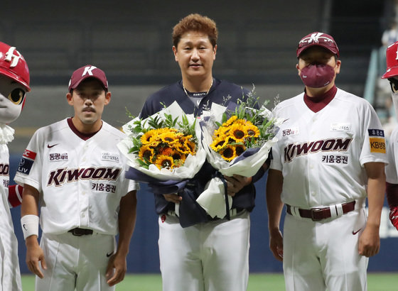 롯데 자이언츠 이대호가 31일 오후 서울 구로구 고척스카이돔에서 프로야구 ‘2022 신한은행 SOL KBO리그’ 롯데 자이언츠와 키움 히어로즈의 경기에 앞서 열린 은퇴투어 행사에서 키움 홍원기 감독, 이용규에게 꽃다발을 받은 뒤 기념촬영을 하고 있다. 2022.8.31/뉴스1