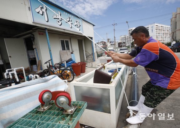 전남 여수 국동에서 상인들이 조립식으로 지어진 식당의 태풍피해를 막기위해 두꺼운 밧줄로 묶는 작업을 하고 있다. 여수=박영철 기자 skyblue@donga.com