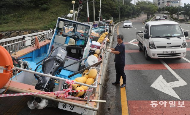 부산 해운대구 송정어촌계 어민들이 도로변으로 소형 어선들을 옮겨 놓고 있다 부산=박경모 기자 momo@donga.com