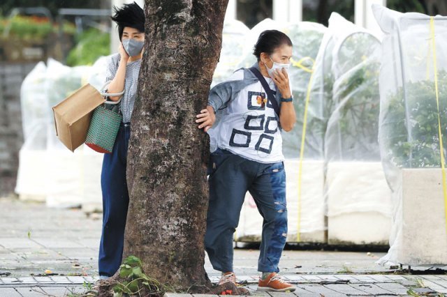 태풍 ‘힌남노’, 日오키나와 지나 한반도로 4일 11호 태풍 힌남노가 상륙한 일본 오키나와현 나하시에서 몰아치는 강풍에 시민들이 나무를 붙잡은 채 버티고 있다. 이날 고령자 여러 명이 바람을 이기지 못하고 넘어져 머리와 팔 등을 다쳤다. 나하=AP 뉴시스