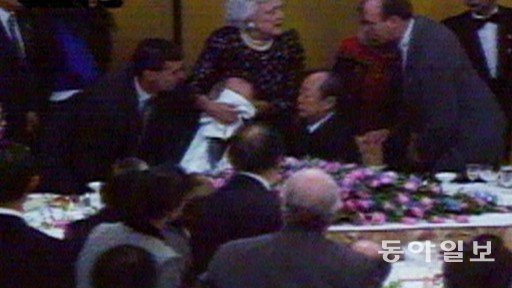 1992년 일본 방문 중이던 조지 H W 부시 대통령이 구토를 하자 부인 바버라 여사가 입에 냅킨을 대고 있는 모습. ABC방송 캡처