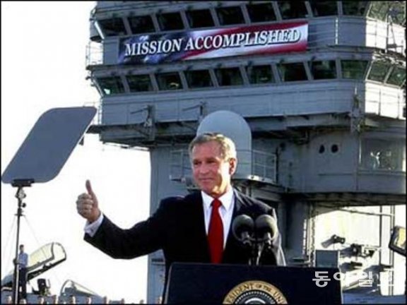 항공모함 에이브러햄 링컨호 선상에서 열린 연설에서 ‘mission accomplished’(임무 완수)라고 적힌 현수막 앞에서 이라크전 승리 연설을 하고 있는 조지 W 부시 대통령. 백악관 폼페이지
