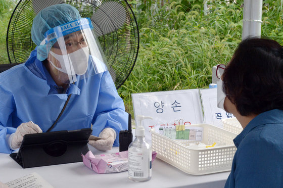 민족대명절 추석 당일인 10일 오후 광주 서구 치평동 5·18교육관 주차장에 마련된 임시 선별진료소에서 의료진이 시민에게 코로나19 검사 안내를 하고 있다. 2022.9.10/뉴스1