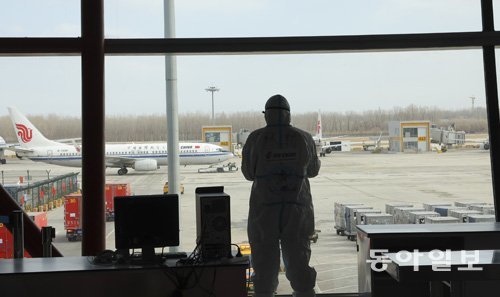 베이징 공항에 방역복을 입은 관계자가 서 있다. 원대연 기자 yeon72@donga.com
