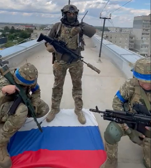 러시아 국기 밟고 선 우크라軍 9일(현지 시간) 우크라이나군이 탈환한 하르키우 발라클리야 마을 건물 옥상에서 병사 세 명이 러시아 국기를 밟고 서 있다. 우크라이나 국방부 트위터 캡처