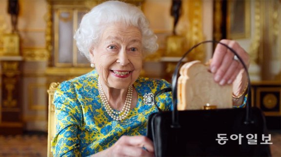 올해 6월 즉위 70주년 기념 동영상에서 핸드백에서 샌드위치를 꺼내며 장난스러운 미소를 짓는 엘리자베스 2세 영국 여왕. 영국 왕실 홈페이지