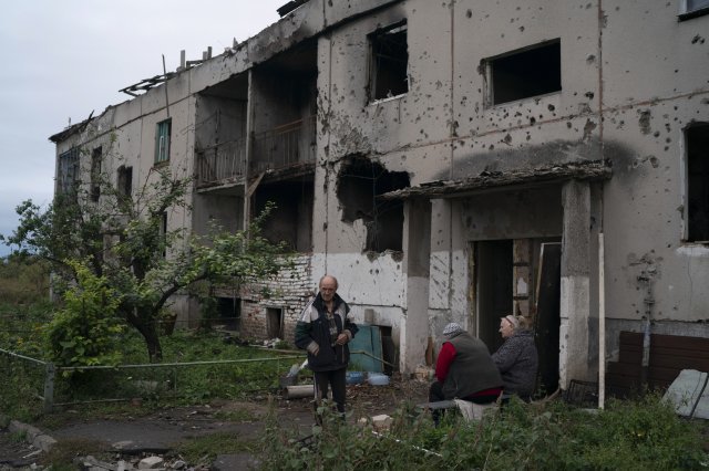 13일(현지 시간) 러시아군이 황급히 퇴각한 우크라이나 하르키우주 남동부 흐라코브의 포격 맞은 주택가 거리에 주민들이 모여 있다. 흐라코브=AP 뉴시스