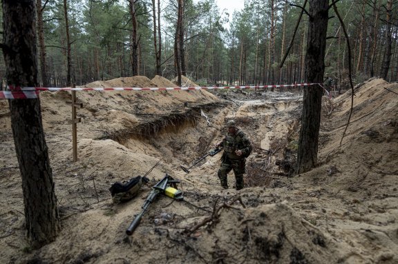 15일 우크라이나 이줌에서 발견된 집단 매장지에 폭발물이 있는지 파악하기 위해 우크라이나군이 금속 탐지기를 작동하고 있다. 이지움=AP 뉴시스