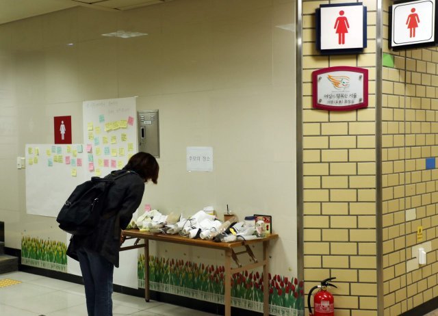 15일 참극이 일어난 서울 중구 지하철 2호선 신당역 여자 화장실 앞에 설치된 추모 공간을 16일 오전 찾은 한 여성이 커피를 올려놓으며 피해자를 추모하고 있다. 신원건 기자 laputa@donga.com